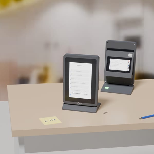 Bancone di un ufficio con la postazione installata: display da 8 pollici rivolto alla persona e modulo operatore agganciato dietro.