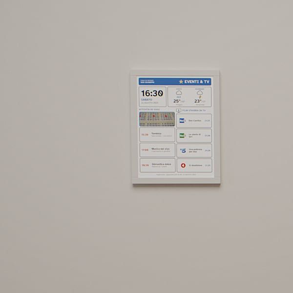 An activity room: an eInk label beside the table shows the day's programme of appointments.