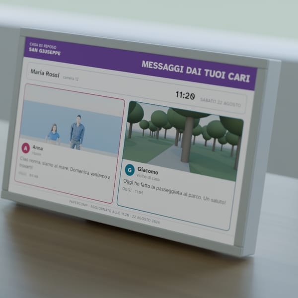 Render: the 10.1-inch label standing on a bedroom table showing two messages from relatives, with a notepad and a pen beside it.